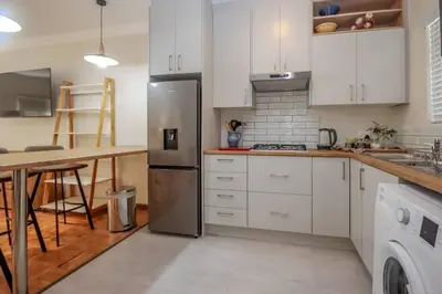 a kitchen with white cabinets and a stainless steel refrigerator at #Spacious Cozy Stay- Free parking in Stellenbosch