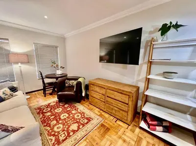 a living room with a bed and a couch and a tv at #Spacious Cozy Stay- Free parking in Stellenbosch