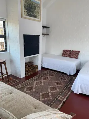a room with two beds and a flat screen tv at Two Palms Cottage in Hermanus