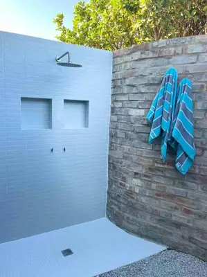 two blue surfboards are hanging on a brick wall at Amazing Brand New Holiday Home with Pool! in Hermanus