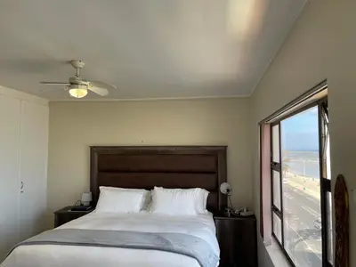 a bedroom with a bed with a view of the ocean at Sea View Serenity on Strand in Cape Town