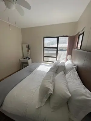 a bedroom with a large bed with white pillows at Sea View Serenity on Strand in Cape Town