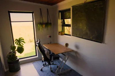 a classroom with a desk and a chair and a window at Fynbos Cottage with Sea View - Self-catering in Bettyʼs Bay
