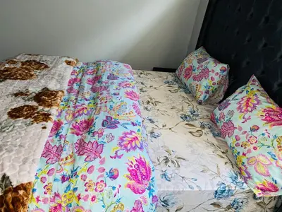 a bed with a comforter and two pillows on it at 22clyde street bostin in Cape Town