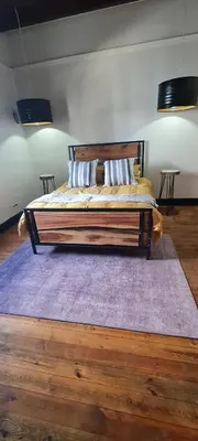 a bedroom with a large bed with a purple rug at Villa Villiers in Villiersdorp