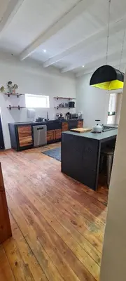 a large room with a kitchen with wooden floors at Villa Villiers in Villiersdorp