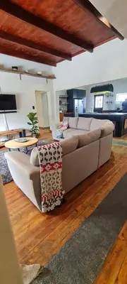 a living room with a large couch and wooden floors at Villa Villiers in Villiersdorp
