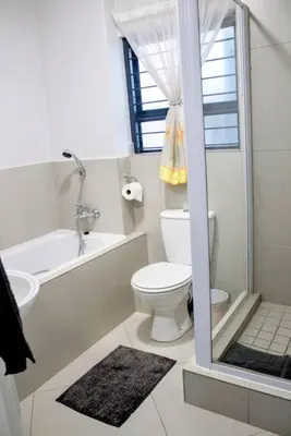 a bathroom with a toilet and a tub and a sink at 7 on Laibach - Buhrein Estate, Kraaifontein in Cape Town