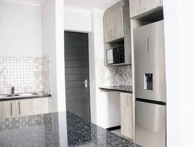 a kitchen with a stainless steel refrigerator and a sink at 7 on Laibach - Buhrein Estate, Kraaifontein in Cape Town