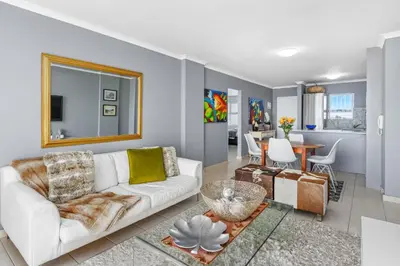 a living room with a white couch and a table at The Waves 302 in Cape Town