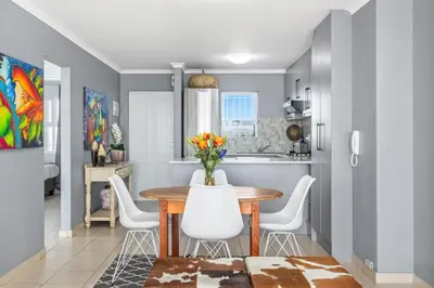 a kitchen and dining room with a table and chairs at The Waves 302 in Cape Town