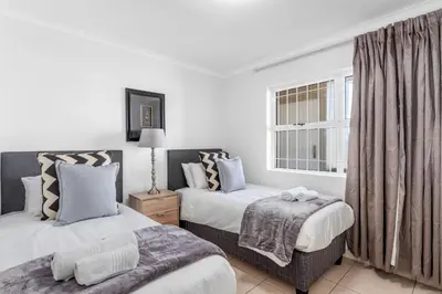 a bedroom with two beds and a window at The Waves 302 in Cape Town