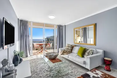 a living room with a couch and a large window at The Waves 302 in Cape Town