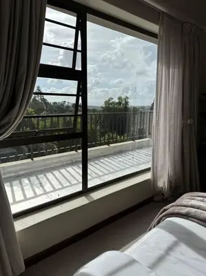 a bedroom with a large window with a view of a balcony at B Shocked Manor - Lux Suites in Cape Town