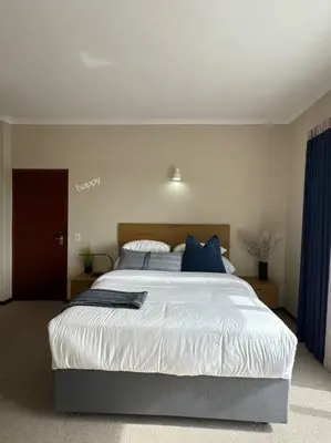a bedroom with a large bed with blue pillows at B Shocked Manor - Lux Suites in Cape Town