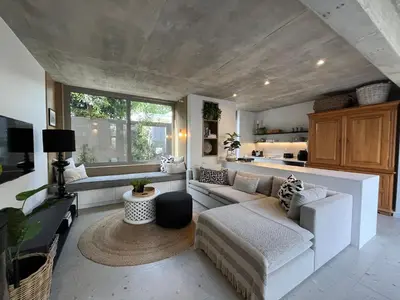 a living room with two couches and a kitchen at The Hermanus Retreat in Hermanus
