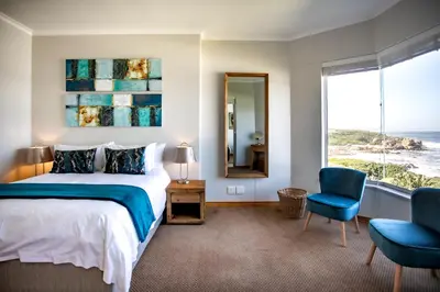 a bedroom with a bed and a large window at Bayview 307 in Hermanus