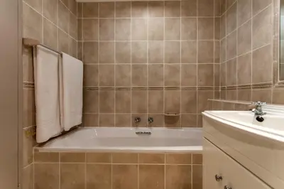 a bathroom with a bath tub and a sink at Bayview 307 in Hermanus