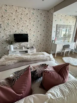 a living room with two beds and a television at Luxury Vineyard Suites in Cape Town