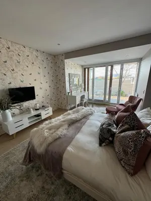 a large bedroom with a large bed and a television at Luxury Vineyard Suites in Cape Town