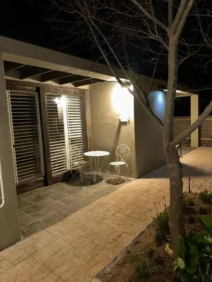 a patio at night with a table and chairs at Luxury Vineyard Suites in Cape Town