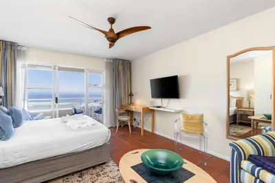 a hotel room with a bed and a view of the ocean at Sea Spray A410 in Cape Town