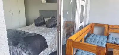 a bedroom with a wooden bunk bed with blue pillows at 35 Amanda - Durbanville in Cape Town