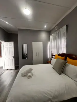 a bedroom with a large white bed with yellow pillows at Mila Lodge 2 in Goodwood