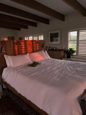 a large white bed in a bedroom with windows at Sublime modern beachfront villa in paradise in Hawston
