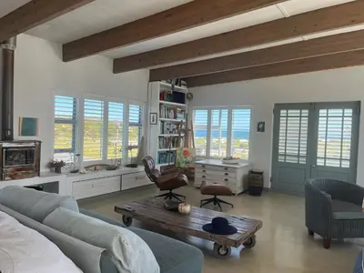 a living room with a couch and a coffee table at Sublime modern beachfront villa in paradise in Hawston