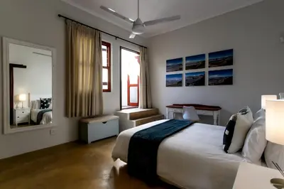 a bedroom with a large bed and a mirror at Plaisir du Cap in Hermanus