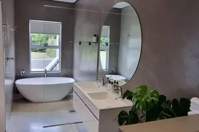 a bathroom with a tub and a large mirror at C'est la Vie 3 in Franschhoek