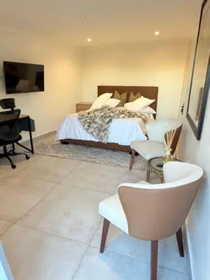 a bedroom with a bed and a desk and a chair at Three Bedroom Apartment in Cape Town