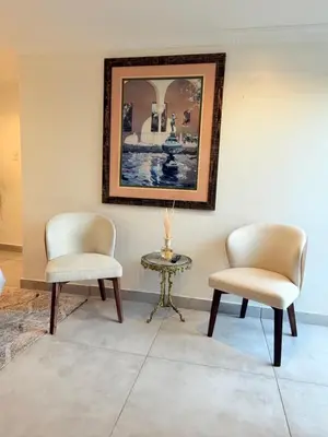two chairs and a table with a picture on the wall at Three Bedroom Apartment in Cape Town