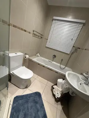 a bathroom with a white toilet and a sink at Three Bedroom Apartment in Cape Town