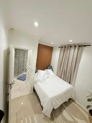 a bedroom with a white bed and a glass door at Three Bedroom Apartment in Cape Town