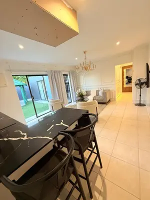 a kitchen and living room with a table and chairs at Three Bedroom Apartment in Cape Town