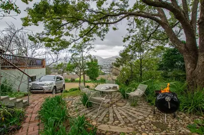 a backyard with a fire pit and a car parked at Mountain View and Vineyard View in Suider-Paarl