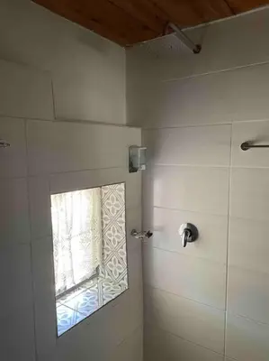 a bathroom with a shower with a window at Mouse House Greyton - tiny home living in Greyton