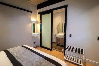 a bedroom with a bed and a bathroom with a mirror at Modern House Dalsig Stellenbosch in Stellenbosch