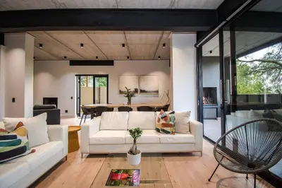 a living room with a white couch and a table at Modern House Dalsig Stellenbosch in Stellenbosch