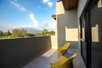 a balcony with two chairs and a view of the sky at Modern House Dalsig Stellenbosch in Stellenbosch