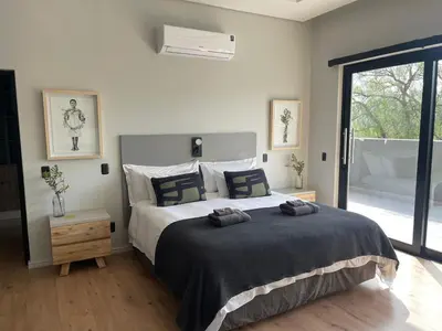 a bedroom with a large bed with two towels on it at Modern House Dalsig Stellenbosch in Stellenbosch