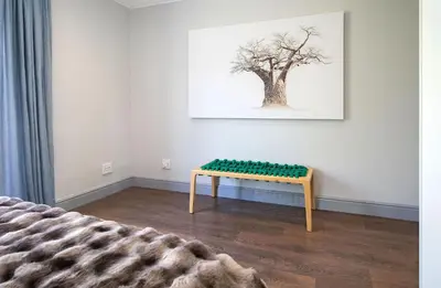 a room with a bench in front of a tree at House La Gratitude - secure parking in Stellenbosch