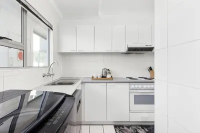 a white kitchen with a stove and a sink at Odeon Towers 1102 in Cape Town