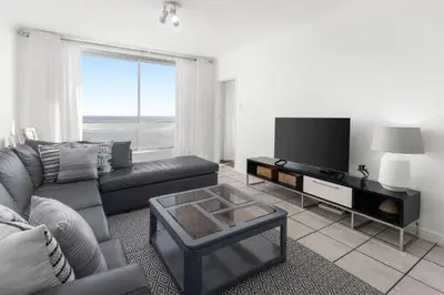 a living room with a couch and a flat screen tv at Odeon Towers 1102 in Cape Town