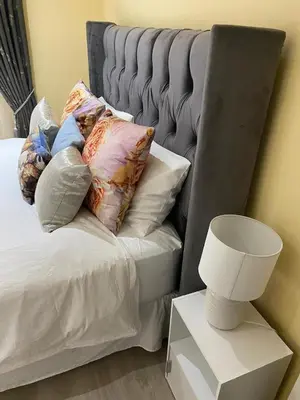 a bed with pillows and a lamp on a table at KBJ House in Cape Town