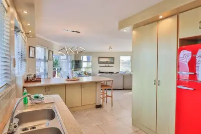 a kitchen with a red refrigerator and a table at Mocha Bay House by the Sea in Bettyʼs Bay