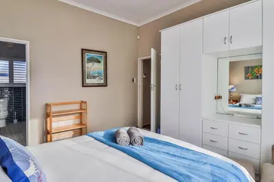 a bedroom with a bed with two pillows on it at Mocha Bay House by the Sea in Bettyʼs Bay