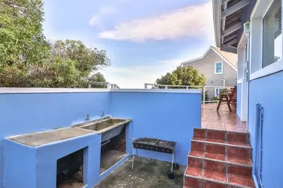 a kitchen with a sink in a blue wall at Mocha Bay House by the Sea in Bettyʼs Bay